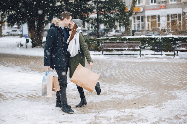 elegante pareja amorosa caminando en la ciudad de la primavera con bolsas de compras