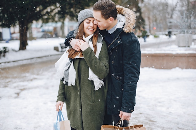 elegante pareja amorosa caminando en la ciudad de la primavera con bolsas de compras