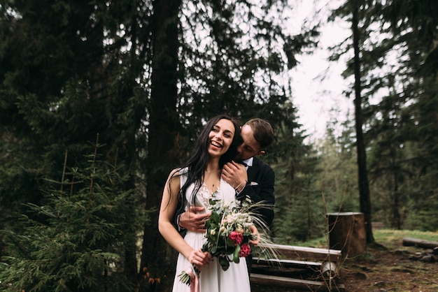 Elegante pareja caminando y abrazándose en la naturaleza