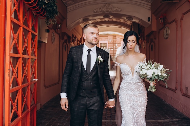 Foto elegante pareja caminando al atardecer, historia de amor, retrato de la novia y el novio el día de la boda