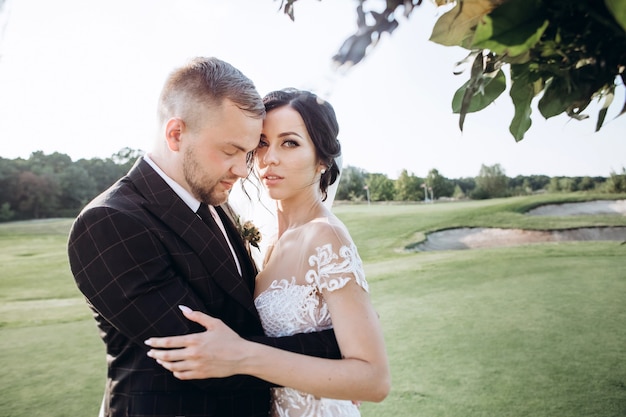 Elegante pareja caminando al atardecer, historia de amor, retrato de la novia y el novio el día de la boda