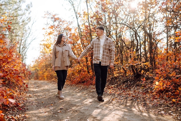 Elegante pareja caminando y disfrutando del clima otoñal Concepto de relajación y vacaciones de la gente