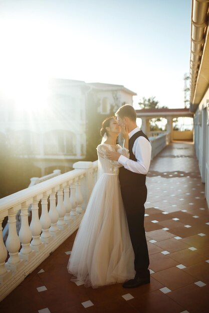 Elegante pareja de felices recién casados posando al atardecer Sexy besándose elegante pareja de amantes al atardecer