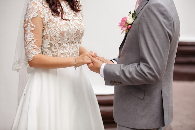 Elegante pareja de novios. Novios cogidos de la mano en el día de la boda