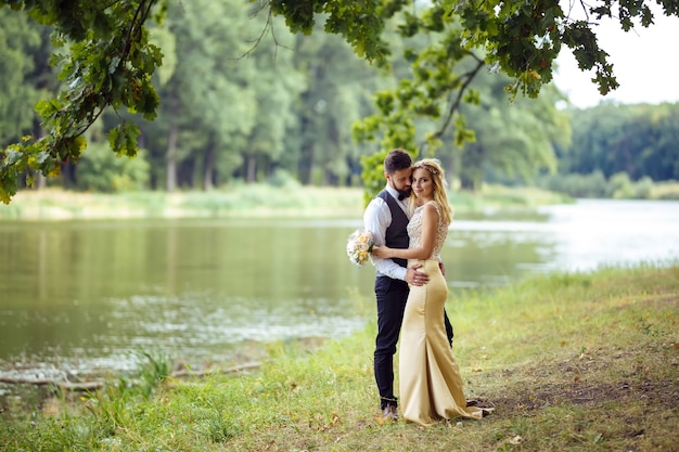 Elegante pareja de recién casados felices posando en el parque el día de su boda Pareja perfecta