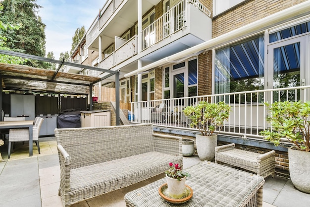 Elegante patio de una casa elegante con sofás de mimbre y una mesa