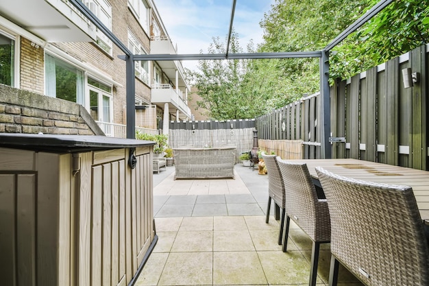 Elegante patio de una casa elegante con sofás de mimbre y una mesa