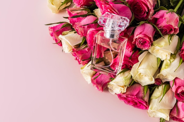Elegante perfume floral em uma garrafa transparente encontra-se nos botões de rosas frescas Um espaço de cópia Conceito de perfume e beleza