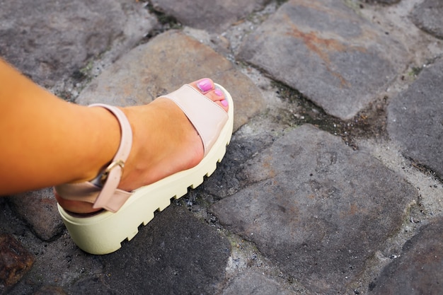 Elegante pierna de niña con pedicura y una hermosa lijadora blanca