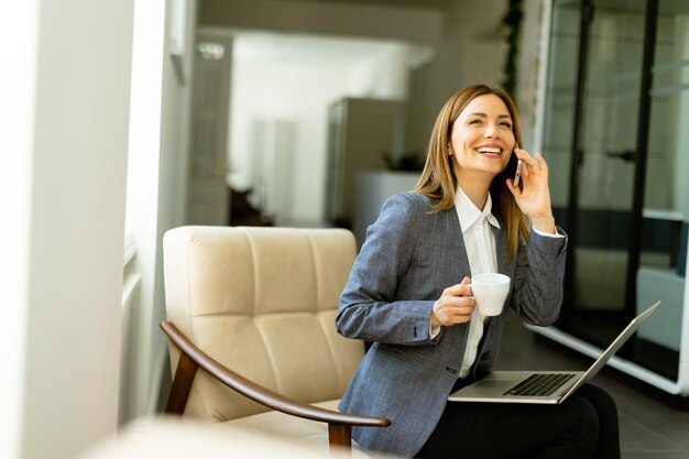 Foto elegante professionelle frau bei einem geschäftsgespräch mit morgenkaffee