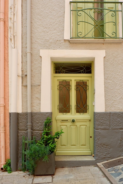 Elegante puerta de madera de color verde claro en el centro de Collioure Francia Puerta delantera vintage detallada en un casco antiguo