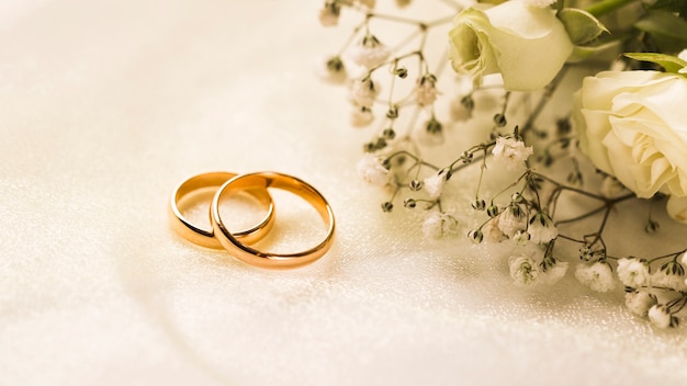 Foto elegante ramo de flores y anillos de compromiso