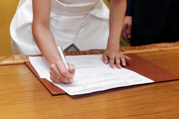 Elegante registro de firma de novia hermosa con pluma y documento oficial pareja de bodas de lujo inusual en estilo retro