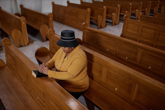 Elegante reife Frau, die in der Kirche betet