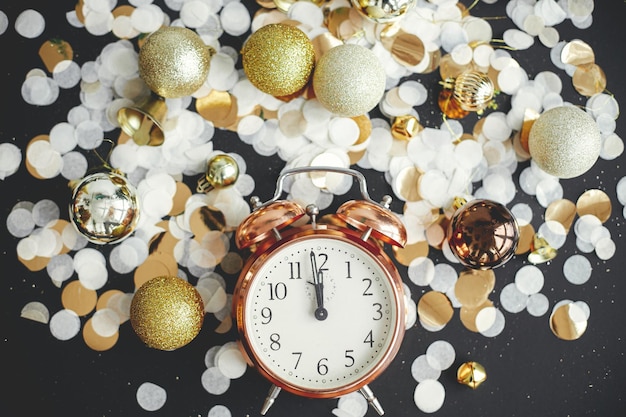 Elegante reloj retro adornos de brillo de navidad y confeti dorado plano feliz año nuevo