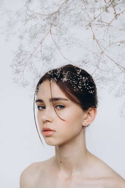 Elegante retrato de una joven con flores de gypsophila y luz natural, belleza natural de niña sin maquillaje, minimalismo y sofisticación.