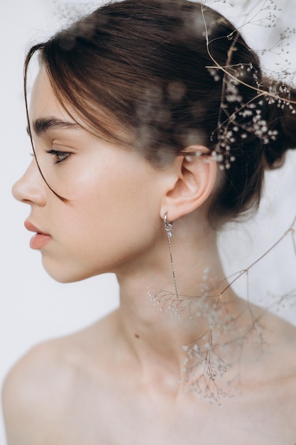 Elegante retrato de una joven modelo de 15 años con luz natural en un espacioso estudio fotográfico