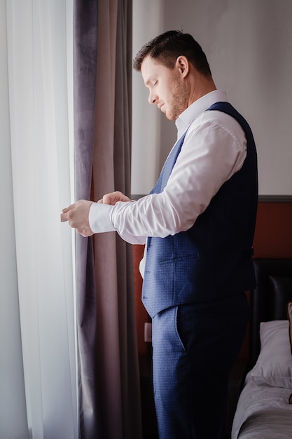 El elegante retrato del novio que se prepara para la ceremonia de la boda por la mañana. Mañana del novio. Preparación matutina del novio.