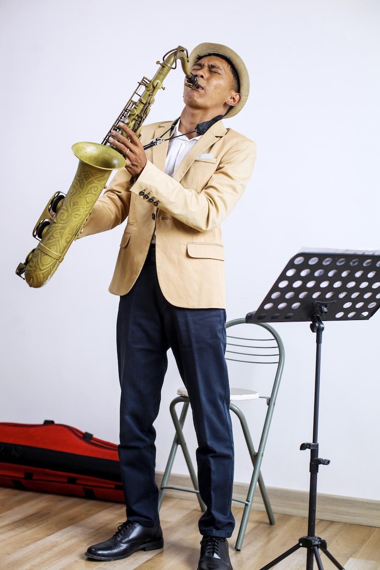 Foto elegante saxofonista tocando un instrumento en el saxofón mientras está de pie en el estudio