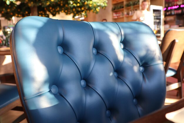 Una elegante silla tapizada azul en un café moderno con un ambiente acogedor y un diseño elegante