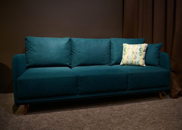 Elegante sofá cama verde con cojín verde y beige a la venta en la sala de exposición de diseño de muebles tapizados