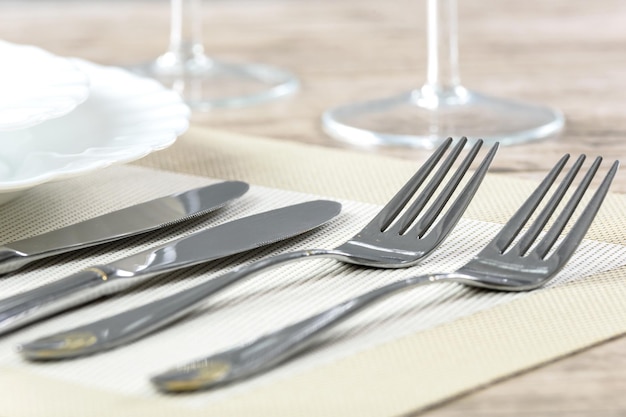 Elegante Tischdekoration im Restaurant mit Tellern, Besteck und Stemware auf einem Holztisch