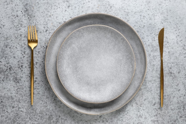 Elegante Tischdekoration mit leerer grauer Platte als Mockup