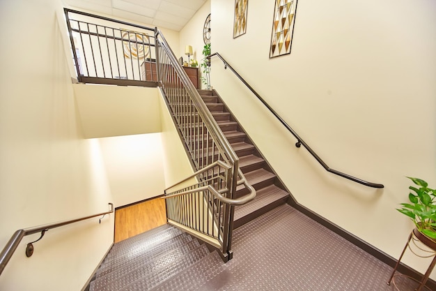 Foto elegante treppe mit sicherheitsmatte und kunstdekoration aufwärtsblick