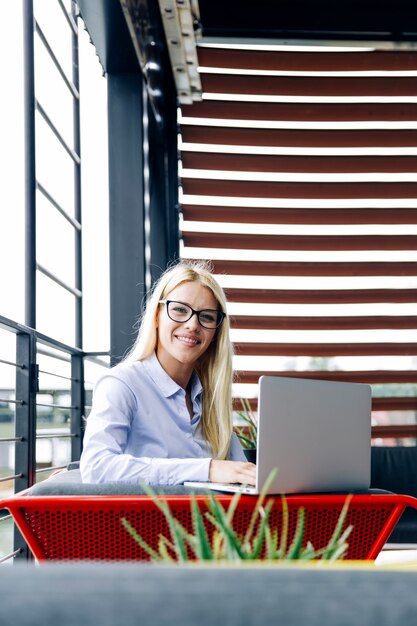 Elegante und fröhliche Geschäftsfrau im modernen Büro