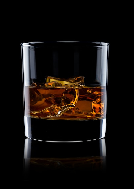 Foto elegante vaso de whisky con cubitos de hielo sobre fondo negro con reflejo