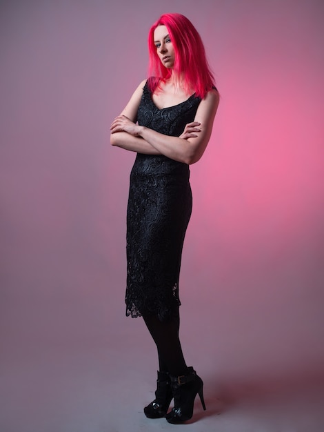 Elegante vestido de encaje negro en una belleza moderna con cabello rosado.