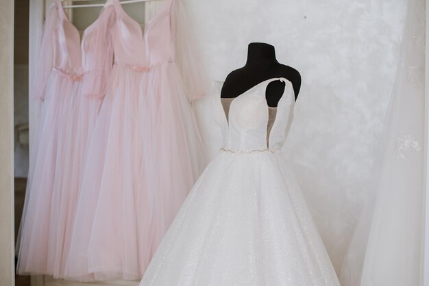 Elegante vestido de novia en un maniquí por la mañana junto a la ventana el día de la boda Preparándose para el día de la boda