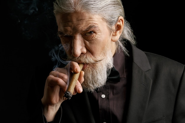 Elegante viejo fumando cigarro.