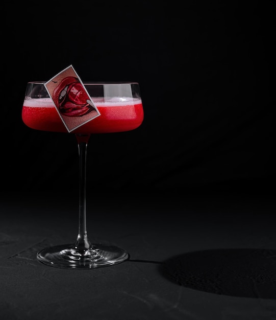 Eleganter Cocktail mit künstlerischer Garnierung auf schwarzem Hintergrund