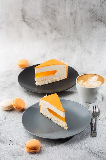 Eleganter Kuchen mit Kokosnuss, Passionsfrucht, Mangos und Bananen, überzogen mit Schokoladenglasur. Scheibe Orangenschichtkuchen auf Marmorhintergrund. Tapete für Konditorei oder Cafémenü. Vertikale.