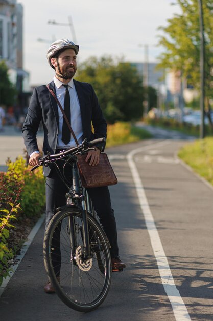 Eleganter Mann im Business-Anzug, der tagsüber in der Stadt radelt