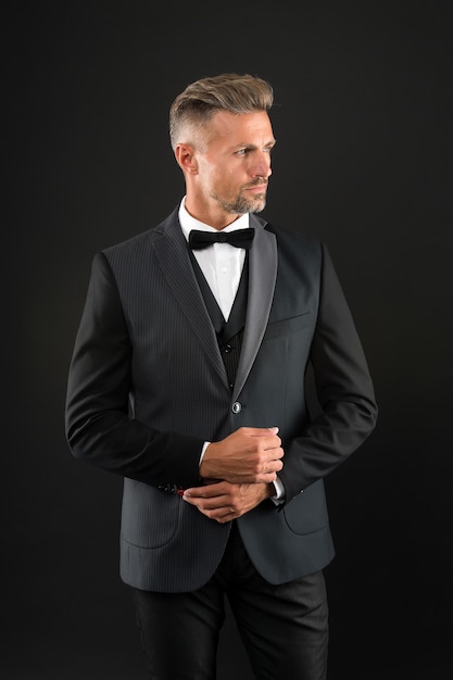 Eleganter Mann im formellen Outfit. hübscher Eventmanager. Smoking-Mann auf schwarzem Hintergrund. perfektes Männchen. Mode und Schönheit. ästhetisches Entwicklungskonzept. bereit für besonderes Datum.