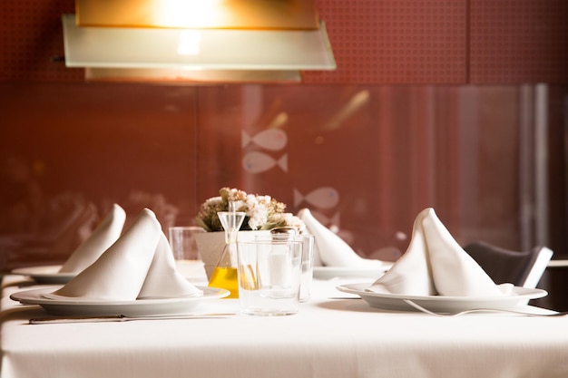 Eleganter Restauranttisch mit Besteck, Geschirr und Gläsern.