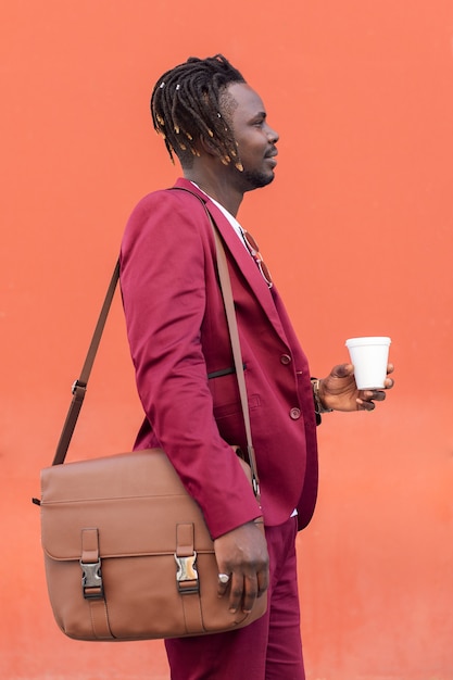 Eleganter schwarzer Mann mit Aktentasche und Kaffee