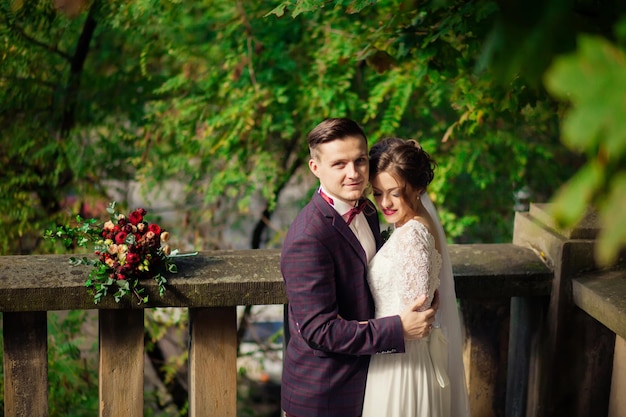 Elegantes Brautpaar posiert an einem Hochzeitstag zusammen im Freien