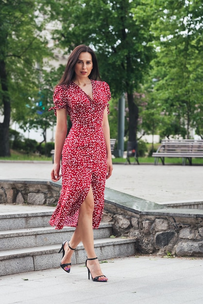 Elegantes brünettes Mädchen, das an der Stadtstraße posiert Hübsche schöne Geschäftsfrau im eleganten Kleid