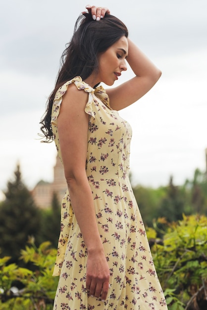 Elegantes brünettes Mädchen, das an der Stadtstraße posiert Hübsche schöne Geschäftsfrau im eleganten Kleid