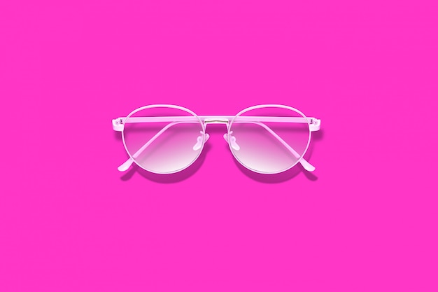 Elegantes gafas rosas sobre superficie rosa