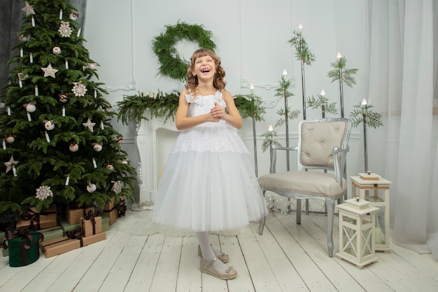 Elegantes Kind am Weihnachtsbaum Kleines fröhliches Mädchen in Weihnachten