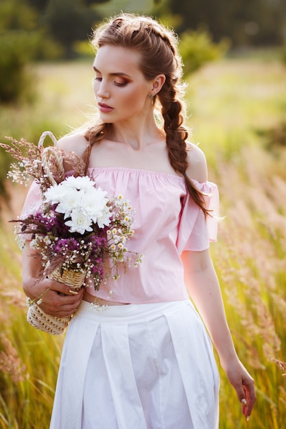elegantes Mädchen mit einem Strauß Wildblumen