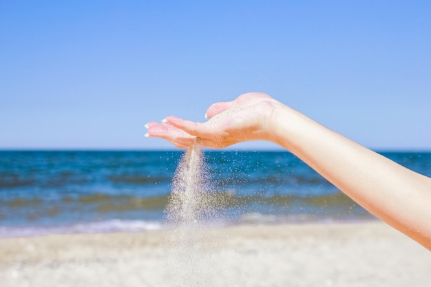 Elegantes mãos lindas sypyat areia mar verão na natureza