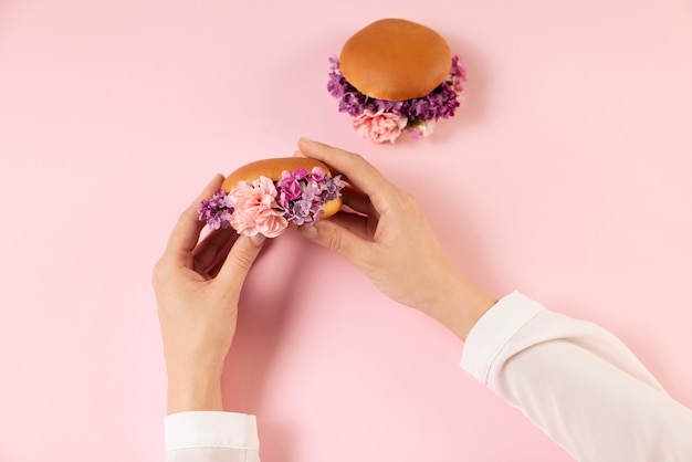 Foto elegantes öko-lebensmittelkonzept mit blumen im burgerbrötchen