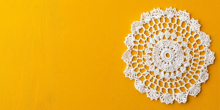 Elegantes pequeñas servilletas blancas de crochet en fondo amarillo con vista aérea del espacio de copia