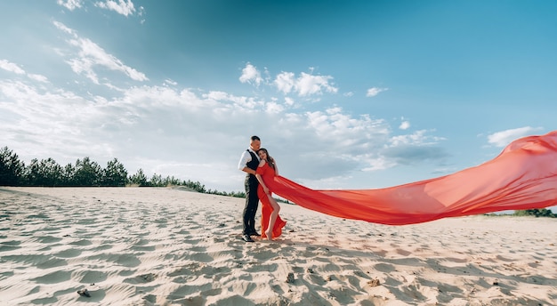 Elegantes schönes Paar, das am Strand aufwirft