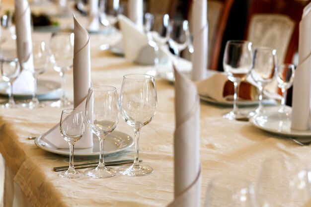 Elegantes vasos y platos vacíos en una mesa elegante para la recepción de bodas en el restaurante